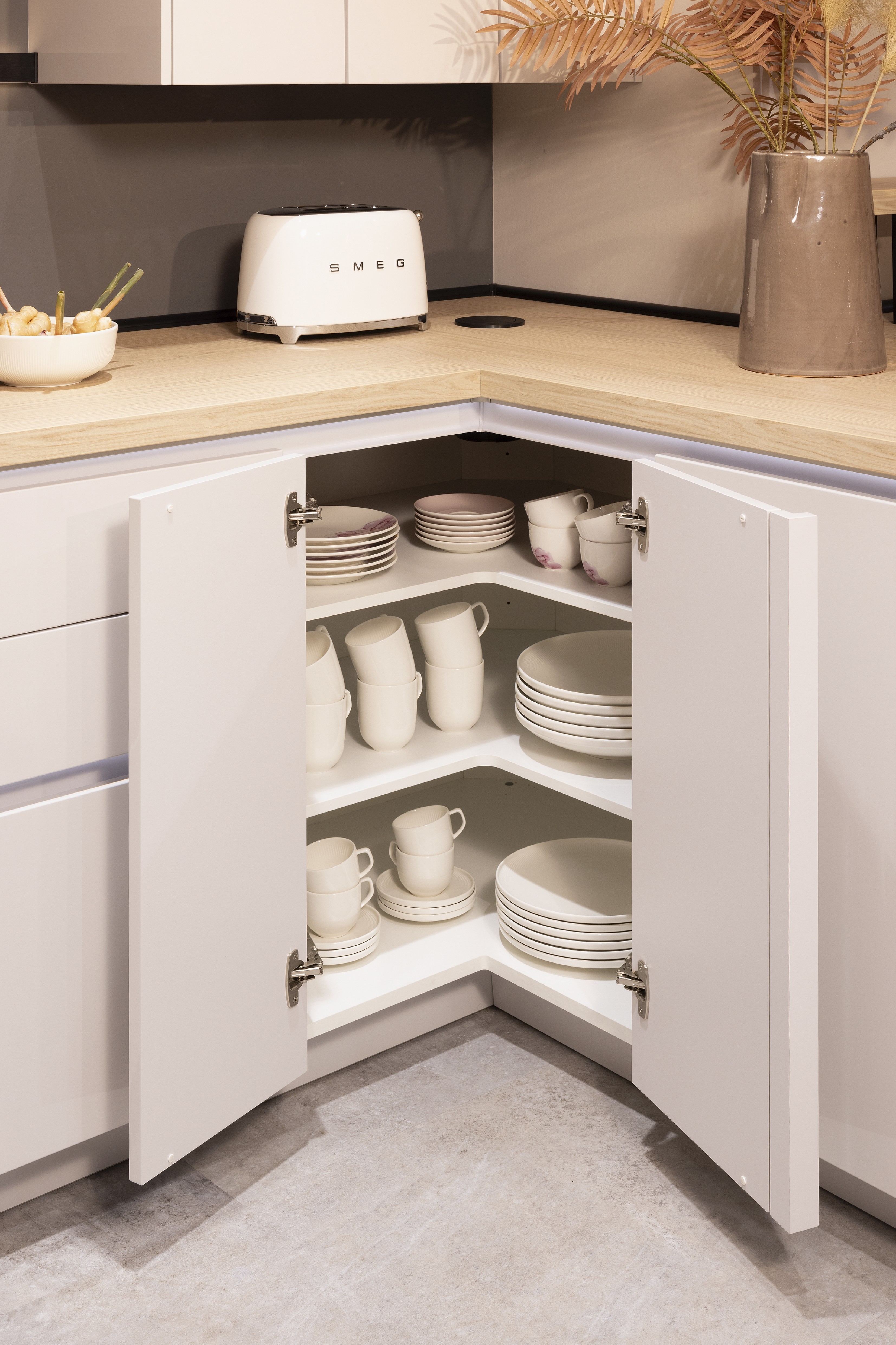 Front: 519 Lack, Seidengrau Hochglanz 362 Eiche Como NB Griff: Push to Open, Schalousienschrank Geräte Bora Downdraft, Bauknecht Spüle: Schock Armatur: Nobili  Features: Living in Küche integriert bzw. gleiche Materialwahl, Materialmix, Rückwand Rillenoptik, Oberschrank Schwarz Glas Lamellen, Touch to open (elektrisch - Climber), Ecklösungen mit Karussell bzw. andere Ecklösung, Arbeitsplatz in Küche integriert, Apothekenschrank, Aluminium Regal Sign-Emotion (Nobilia spezifischer Begriff), Lichtblende