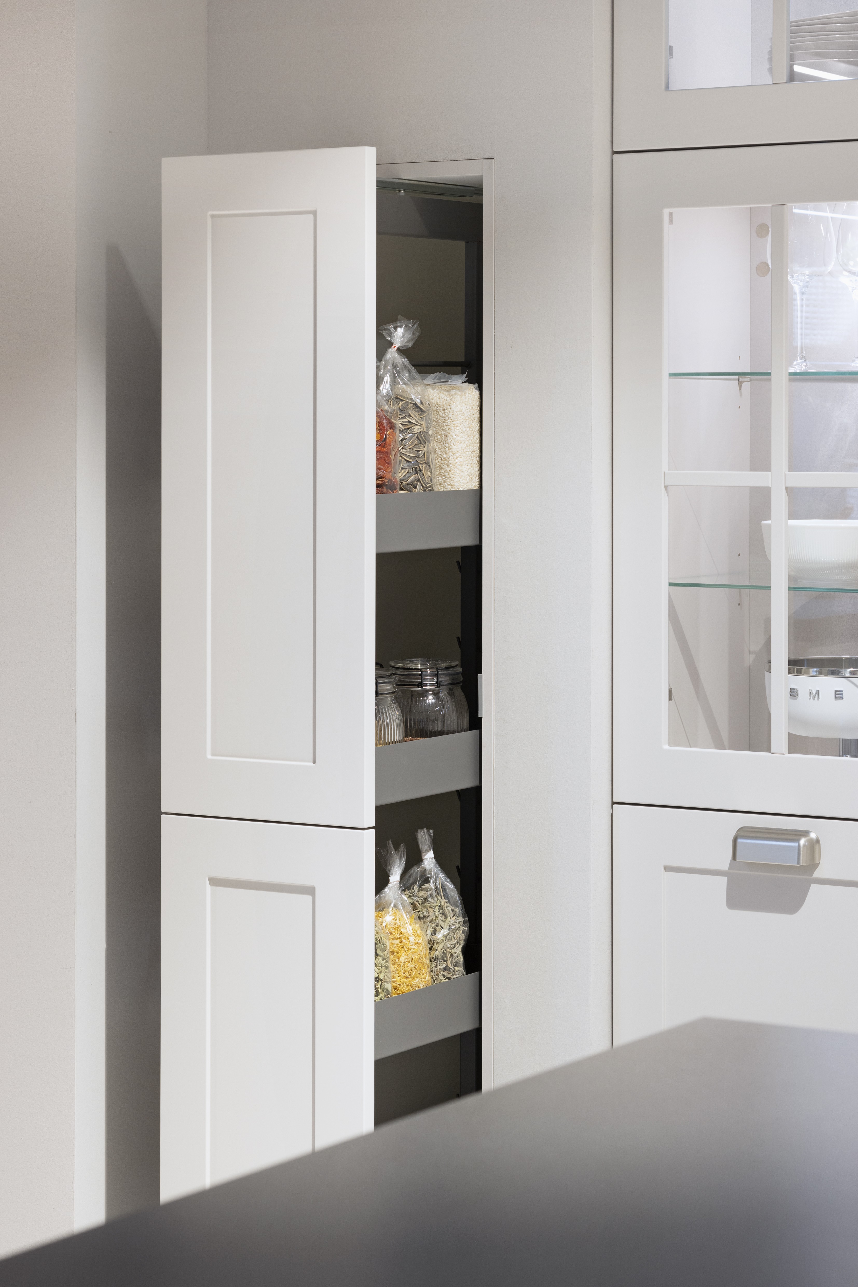 APL: 809 Epic Ash Grain Korpus: 122 Sand Front: 788 Lack, Sand matt  Griff: Aufschraubgriffmuschel Edelstahl-farbig Geräte: Smeg Armatur: Nobili Spüle: Rodi  Features: Landhaus modern, neue Front, Landhaus Backofen von Smeg, bedruckte Fliese als Nischenrückwand, beleuchtete Vitrinen mit Gitter (Landhaus), neue Griffmuschel, eingekofferte Schranklösung, 70er Geräte Einbaukühlschrank mit Front Inox in Edelstahloptik, Thekenlösung mit Barhockern, Dunstabzug als Esse eingebaut, Lichtlösung Dunstabzug. 