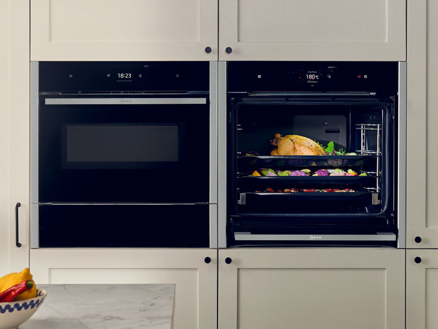 NEFF Einbaubackofen neben Einbau-Dampfgarer helle Küchenfront Landhausstil
