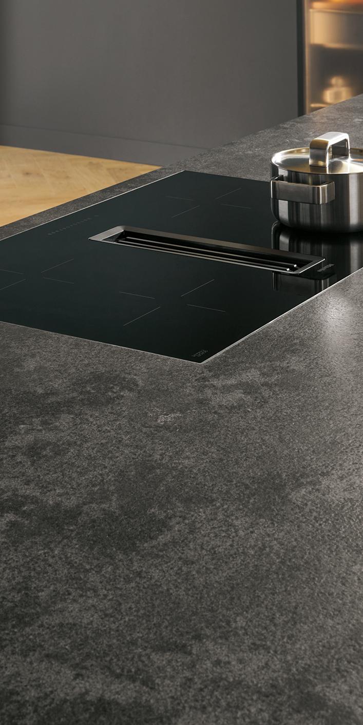 systemo dunkelgraue Naturstein APL mit InduktionsKochfeld und integriertem Muldenlüfter als mittiger Kochfeldabzug-Spalt